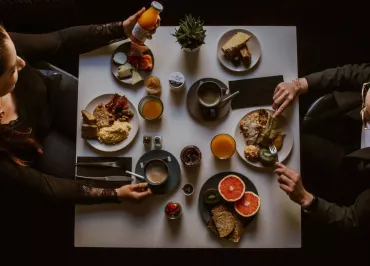 Deux femmes vues de dessus, en train de prendre un petit-déjeuner varié.