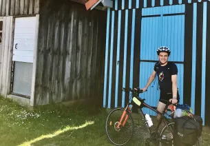 Valentin et son vélo devant une cabane colorée du port de Gujan
