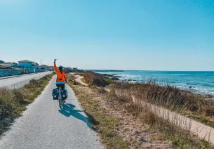 Clémence à vélo sur la piste en bord d'océan