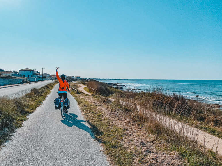 Clémence à vélo sur la piste en bord d'océan